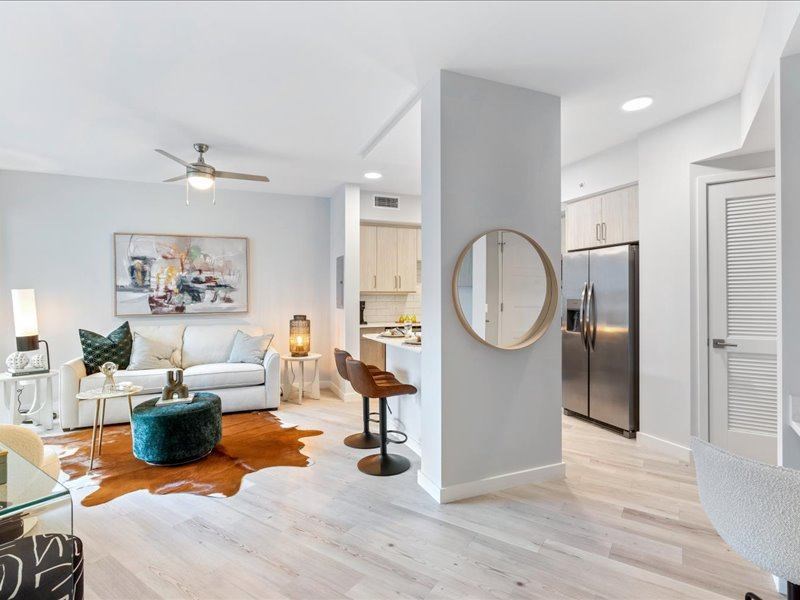 a living room with a round mirror in the middle of it