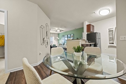a dining room with a glass table and chairs