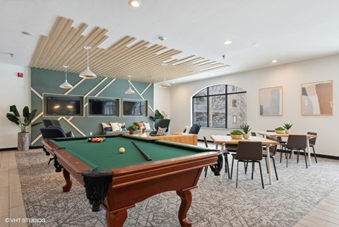 A room with a pool table and a dining table.