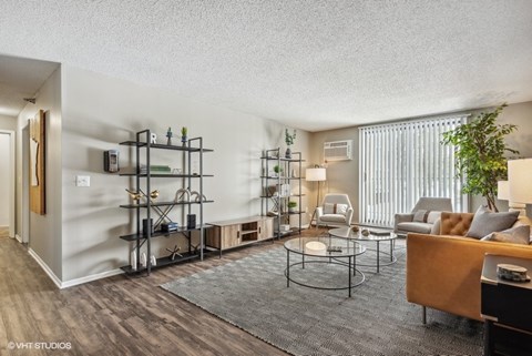 A living room with a grey carpet and a wooden coffee table.