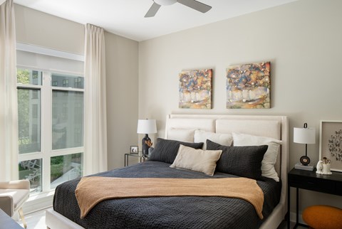 a bedroom with a bed and two paintings on the wall