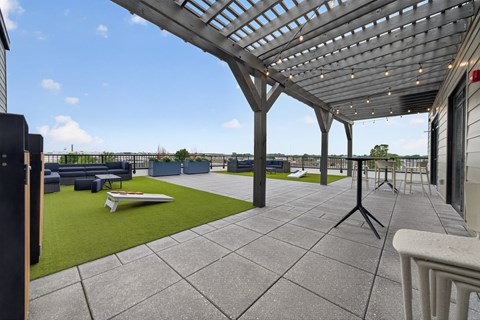 Rooftop Lounge with green space, pergola, and corn hole boards