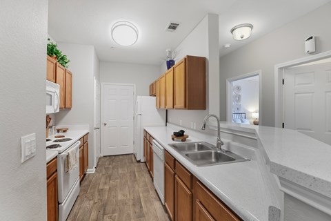 A kitchen with wooden cabinets and white countertops.