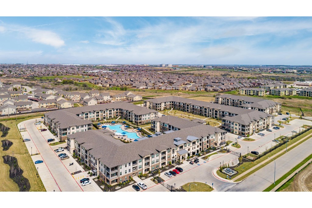 an aerial view of a building with a beach and a blue sky