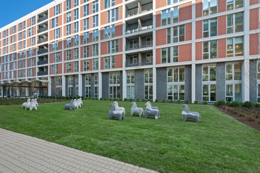 a sculpture of sheep in front of an apartment building