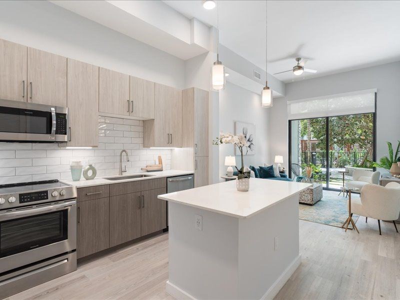 a kitchen with a large center island next to a stove top oven