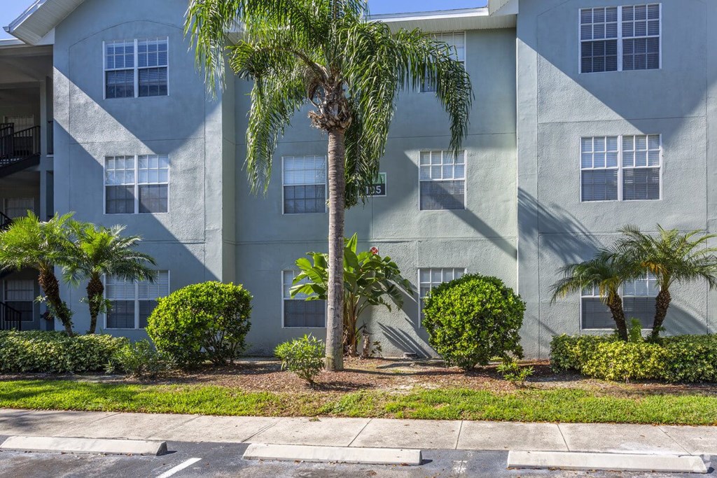 an apartment building with palm trees in front of it