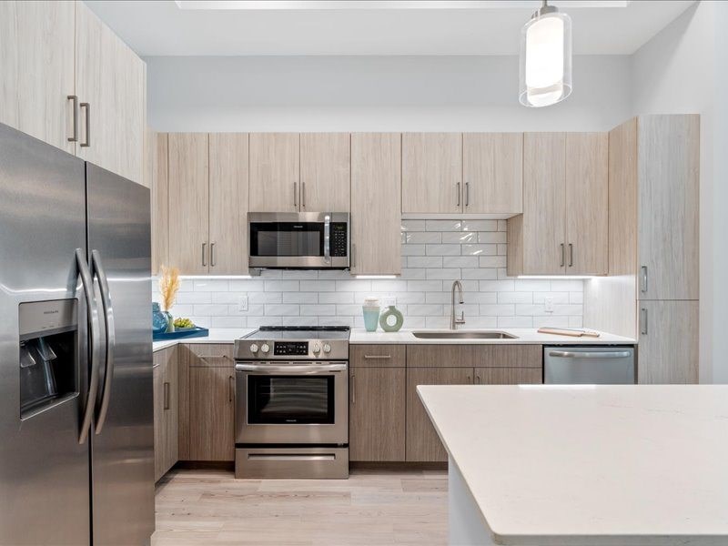 a kitchen with wooden cabinets and stainless steel appliances