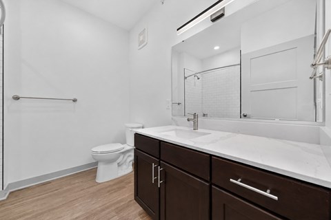 Bathroom with white countertops and brown cabinetry