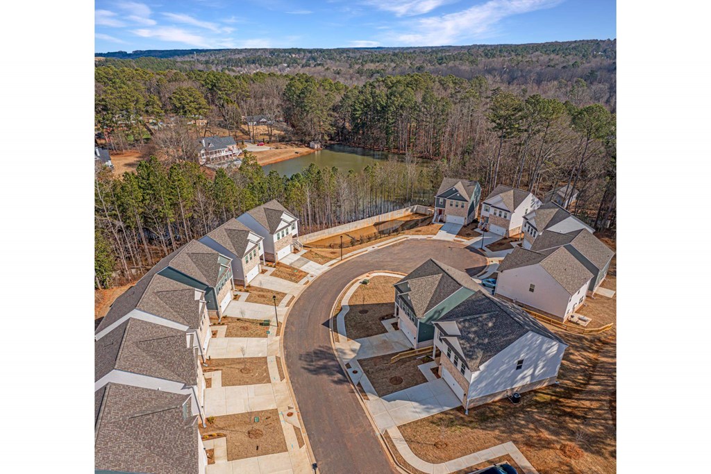 an aerial view of several houses with a lake in the background