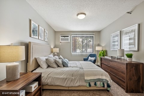 a bedroom with a bed and a dresser and a window