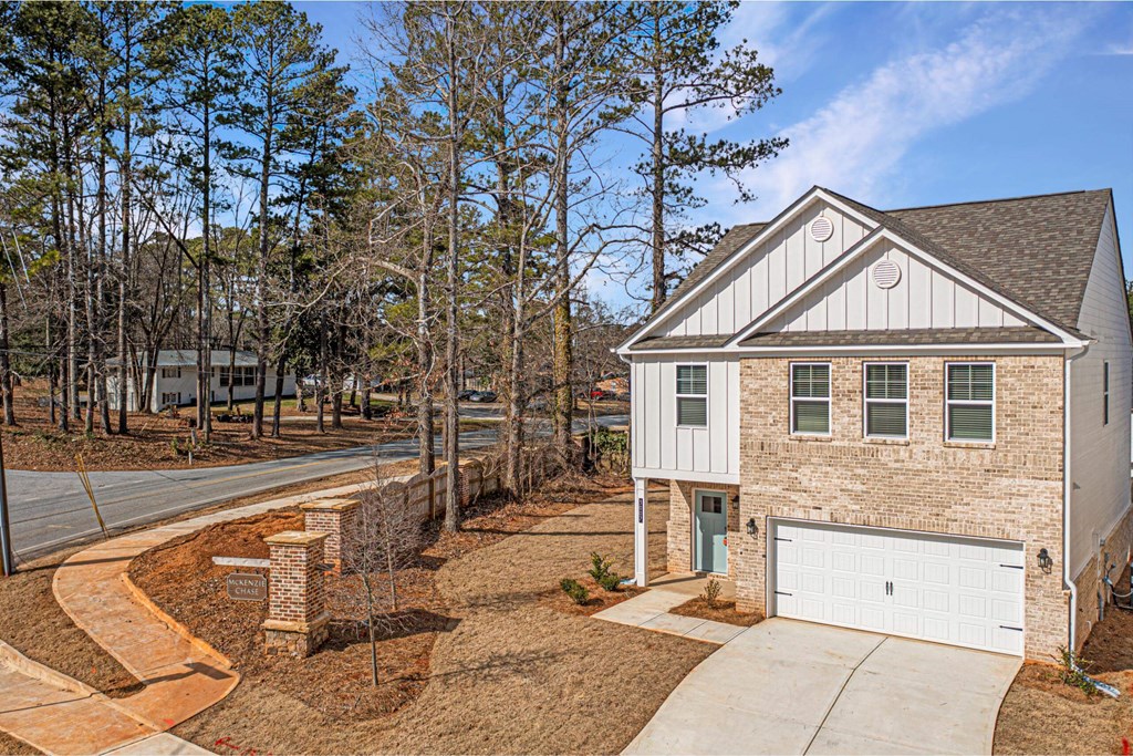 a brick house with a white garage door on a street