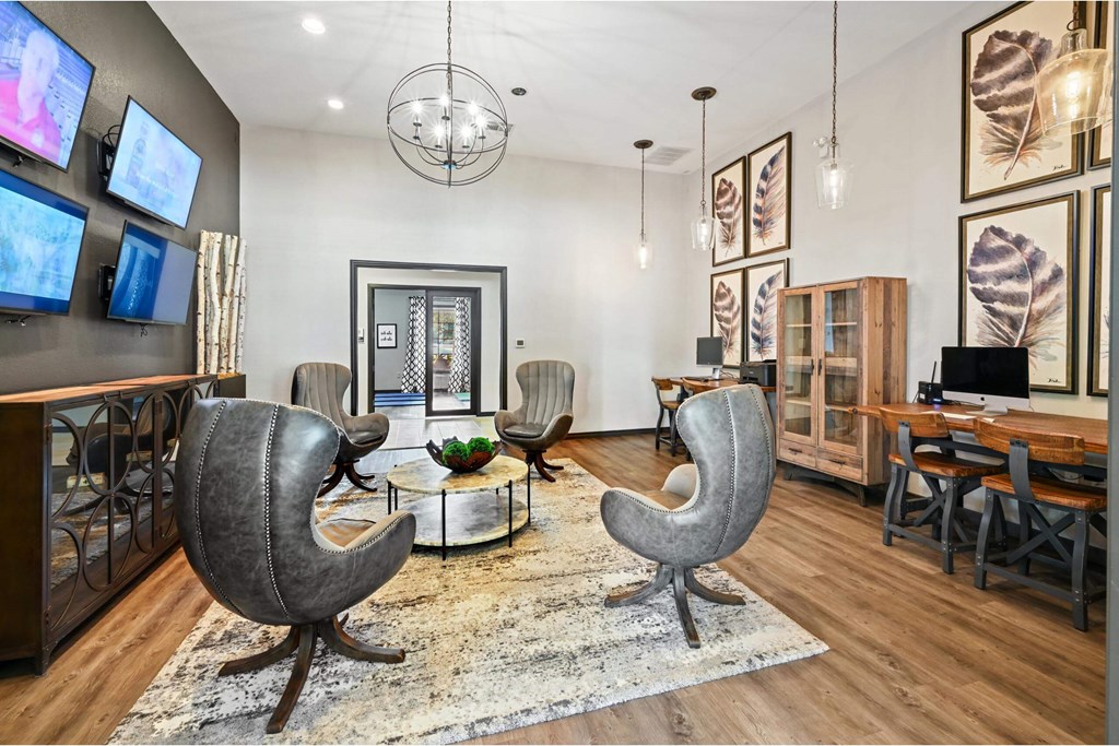 a living room with chairs and a tv