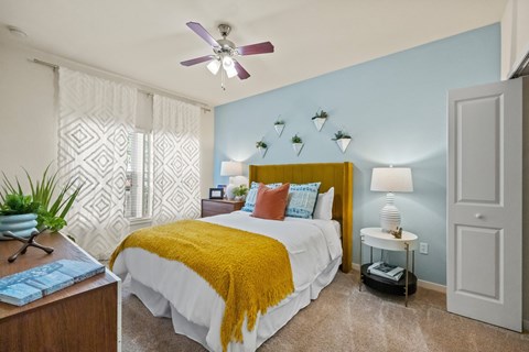 a bedroom with a bed and a ceiling fan