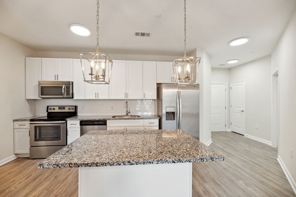 a kitchen with white cabinets and a granite counter top
