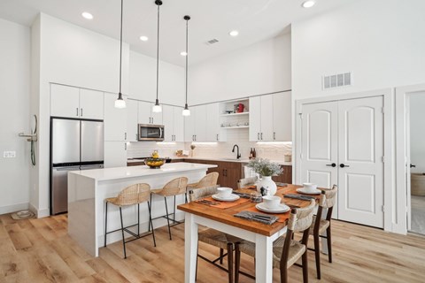 A modern kitchen with a dining table set for four.