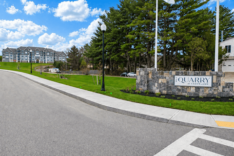 A street view of a residential area with a sign that reads