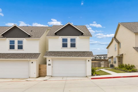A row of houses with garages in front.