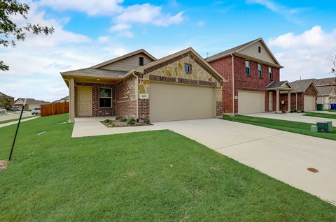 Long and inviting driveway leads to a spacious three-bedroom home, framed by a vast and well-maintained lawn.