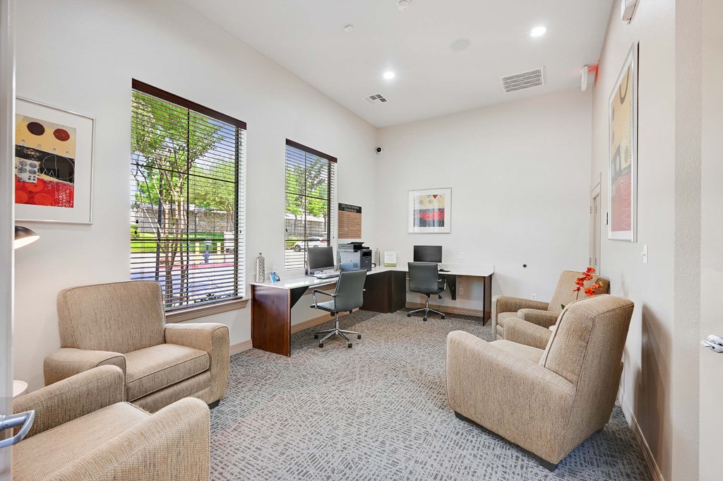 a living room with couches and chairs and a desk with a computer