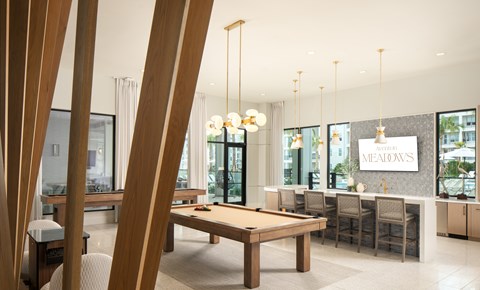 a living room with a pool table and a dining room