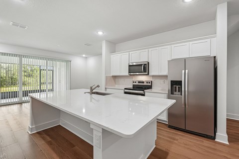 A kitchen with a white countertop and stainless steel appliances.