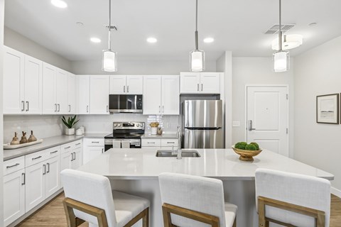A modern kitchen with a large island and white cabinets.