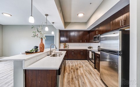 A modern kitchen with wooden cabinets and stainless steel appliances.