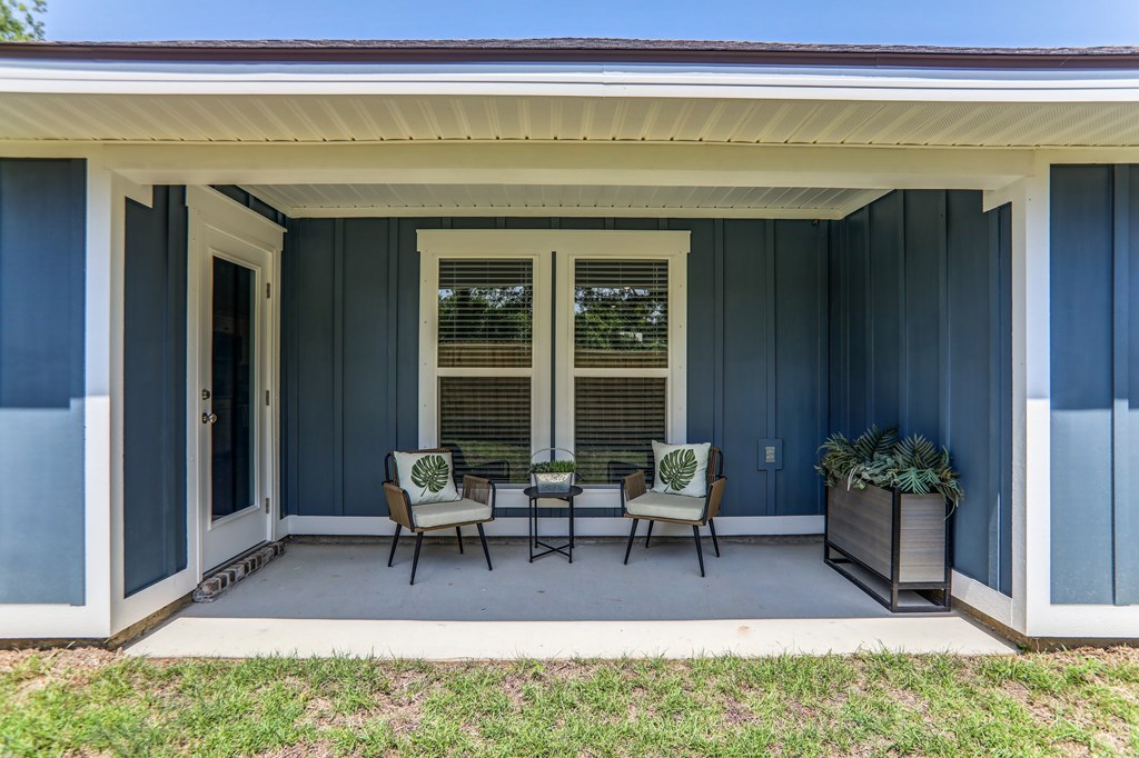 a patio with chairs and a table on a porch
