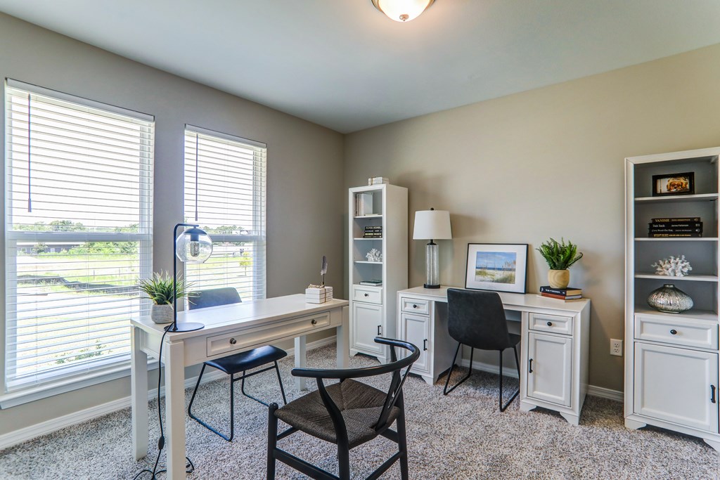 a home office with two windows and a white desk and chairs