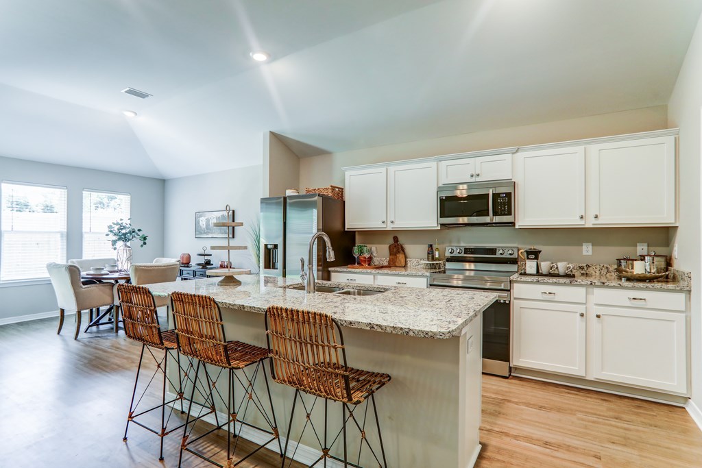 a kitchen with an island with three bar stools