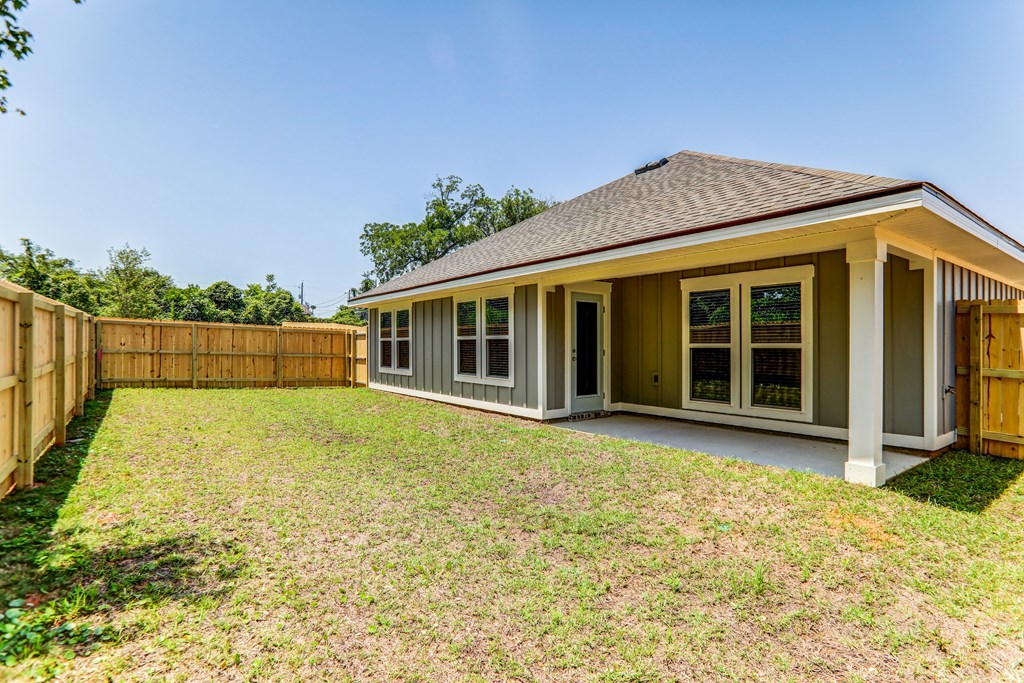 the backyard of a house with a yard and a fence