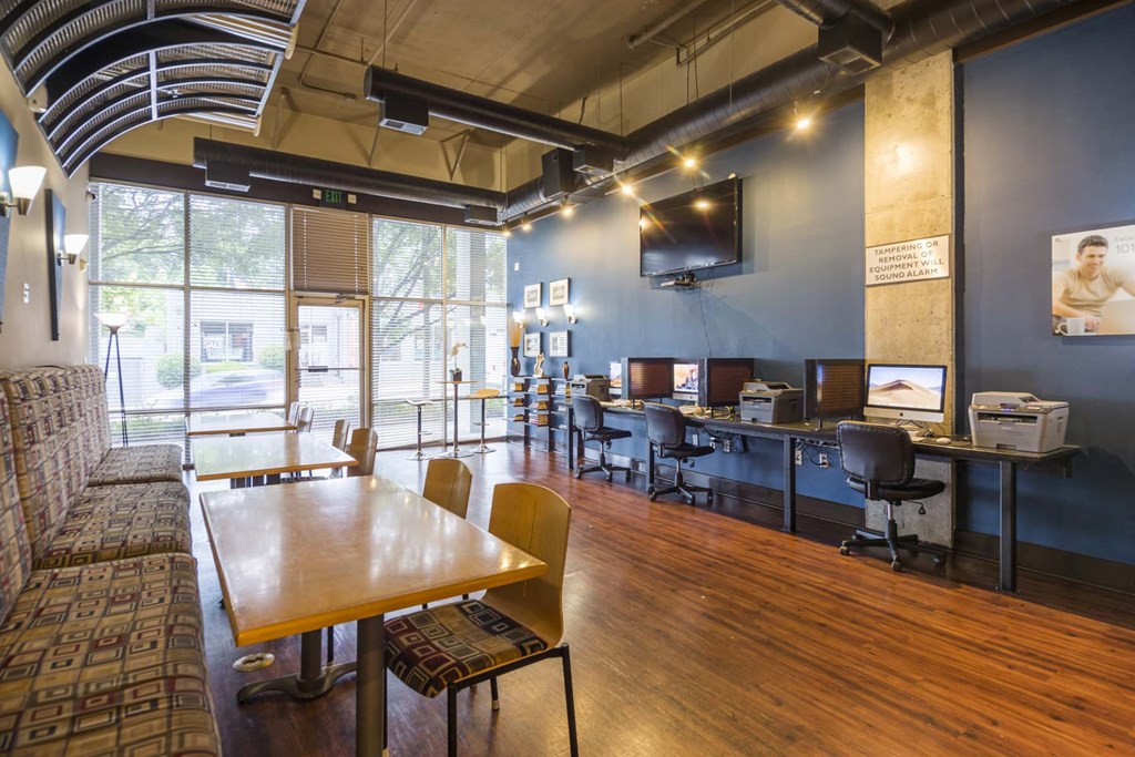 a room with a long wooden table with chairs and a couch