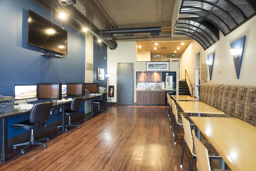 a large room with desks and chairs and a television on the wall