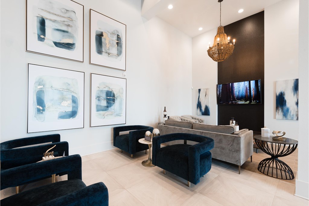 a living room with blue furniture and pictures on the wall