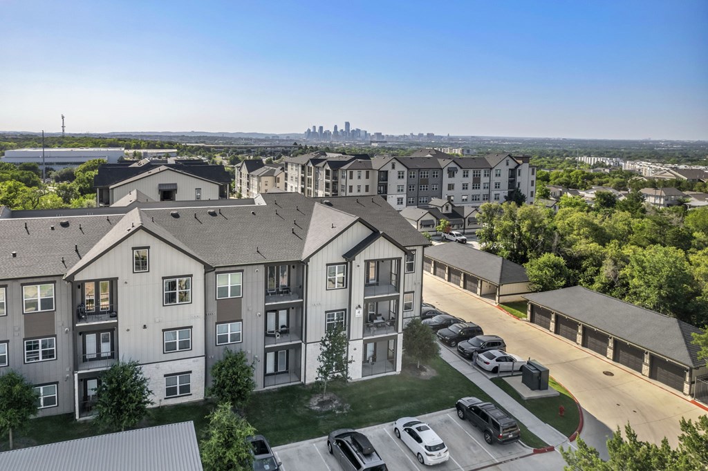 an aerial view of an apartment complex with cars parked in a parking lot