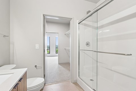 A white bathroom with a walk in shower.
