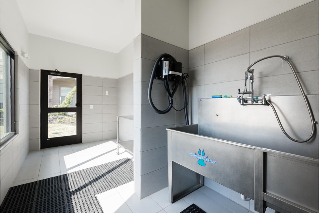 a bathroom with a large stainless steel tub and a shower