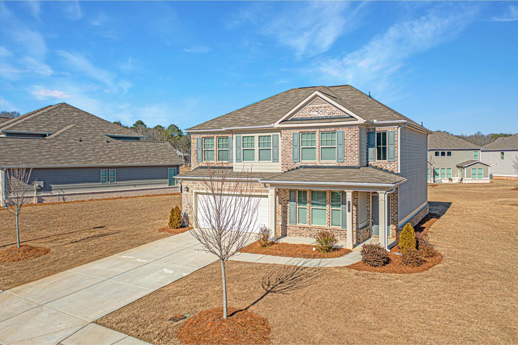 a blue house with a yard and a driveway