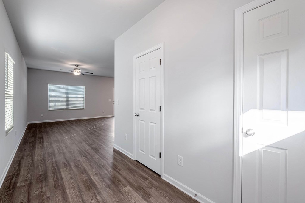 the living room and dining room in a new home with white walls and wood floors