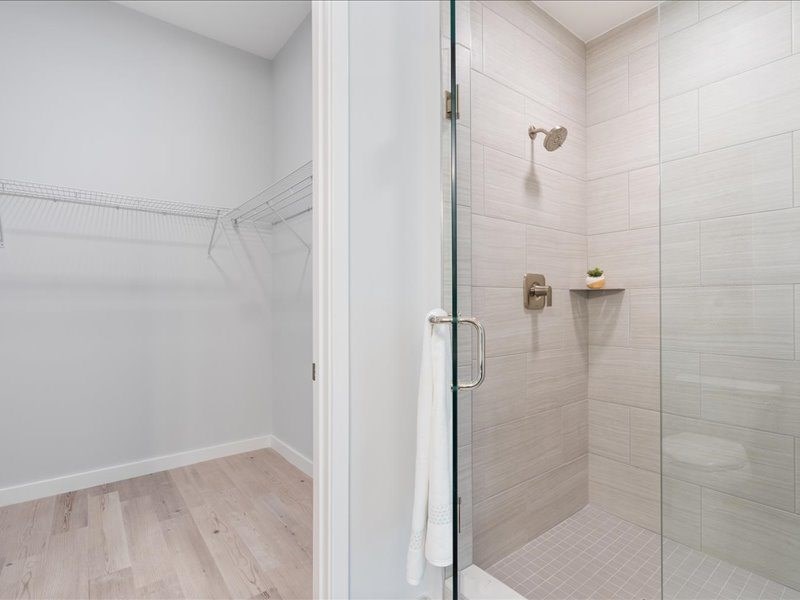 a white bathroom with a glass shower door