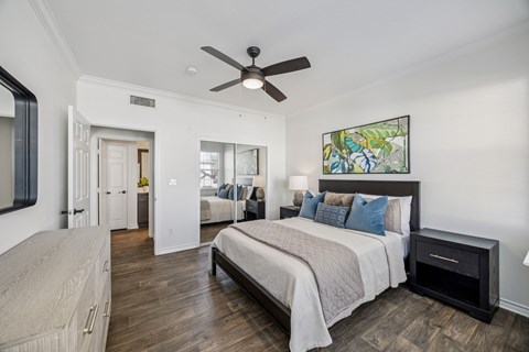 A bedroom with a large bed and a ceiling fan.