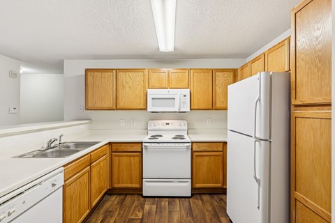 A kitchen with wooden cabinets and white appliances.