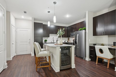 A modern kitchen with dark wood floors and white walls.