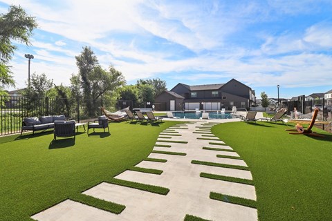 A large outdoor area with a grassy lawn and a pathway with steps at Townhomes at Princeton Meadows