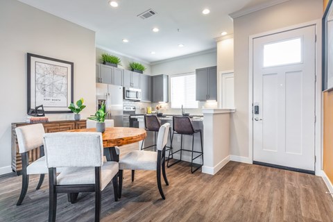 A modern kitchen with a dining table and chairs.