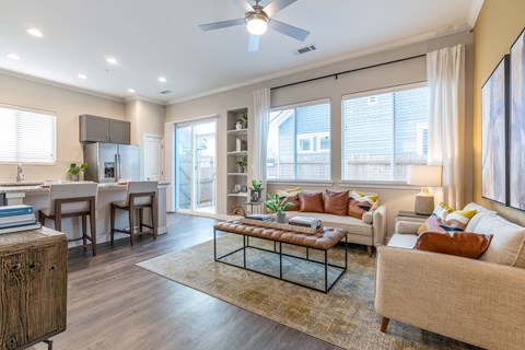 A living room with a couch, a coffee table, and a dining table.