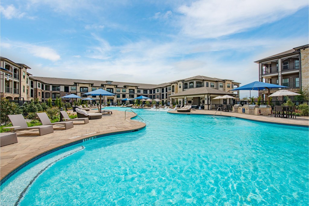 a large swimming pool with apartments in the background