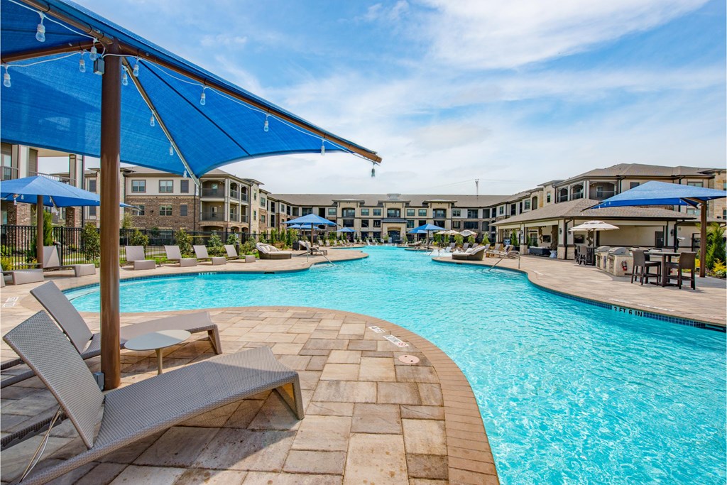 a swimming pool with chairs and umbrellas at the resort