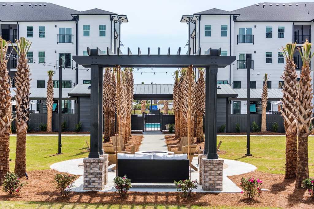 A black bench is in front of a black archway with palm trees on either side.